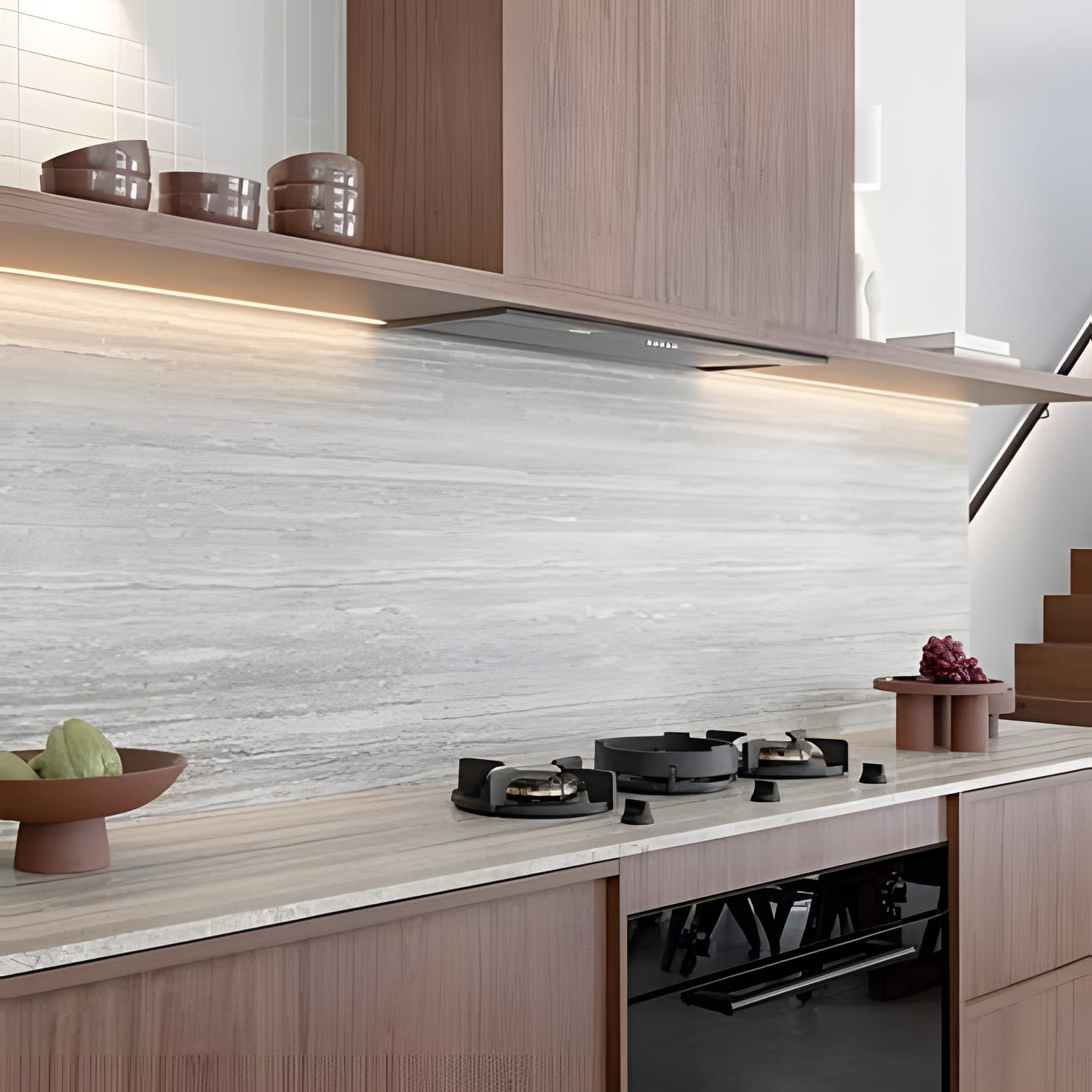 Walnut base cabinets under a grey stone slab backsplash, a single shelf floating above the counter.