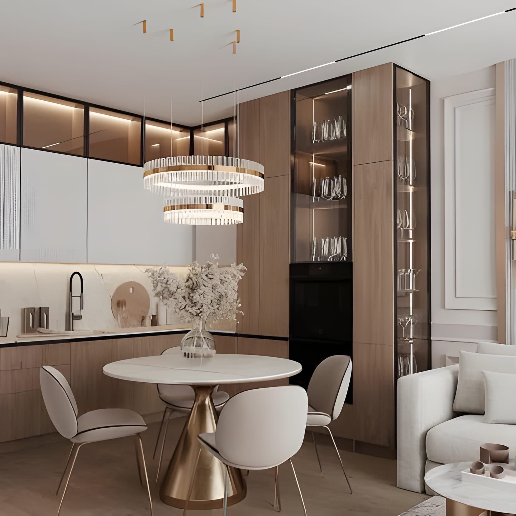 Cream cabinetry around a glass display tower, with a ring chandelier over a round table and white chairs.