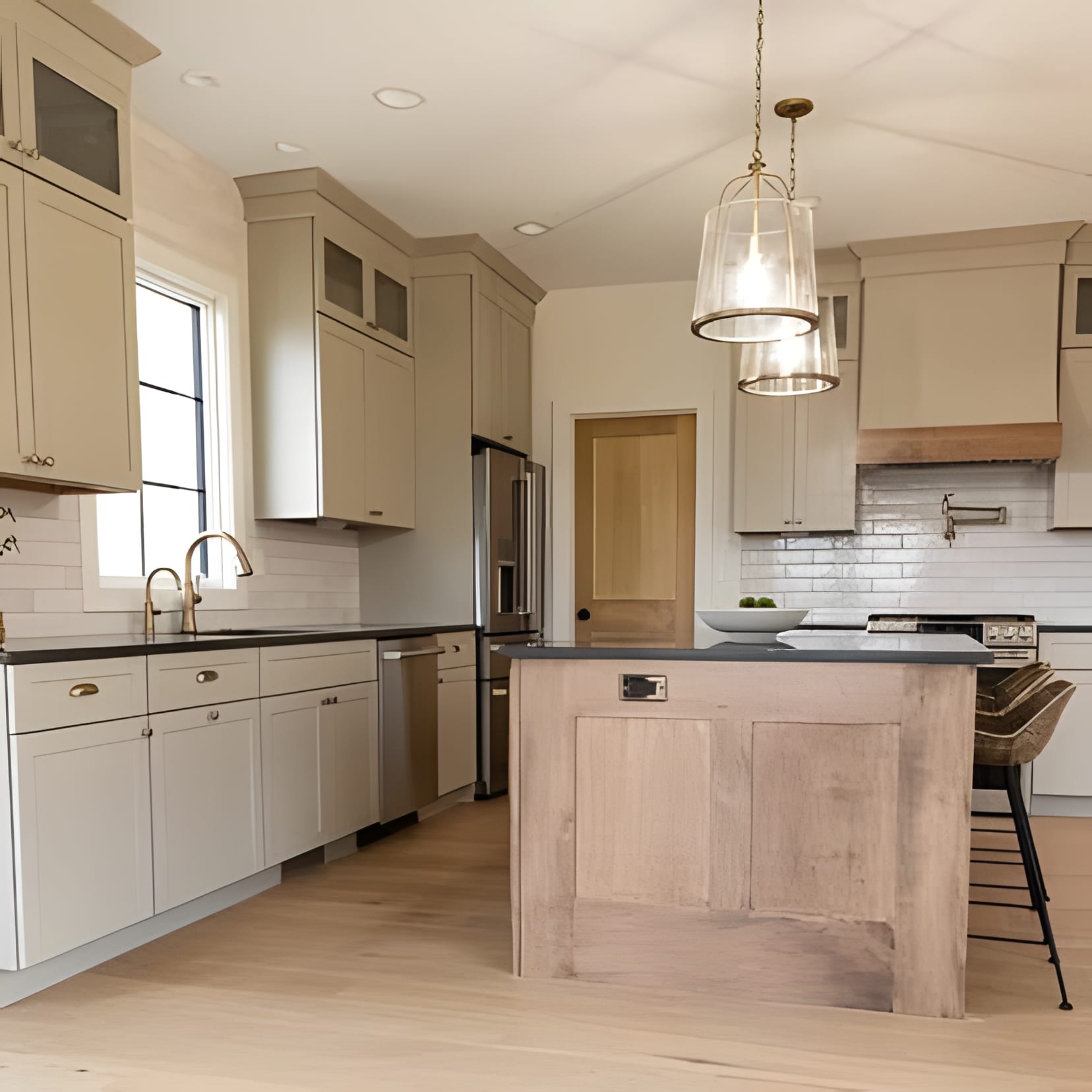 Cream shaker cabinetry around a knotty wood block island, a clear glass pendant hanging low.