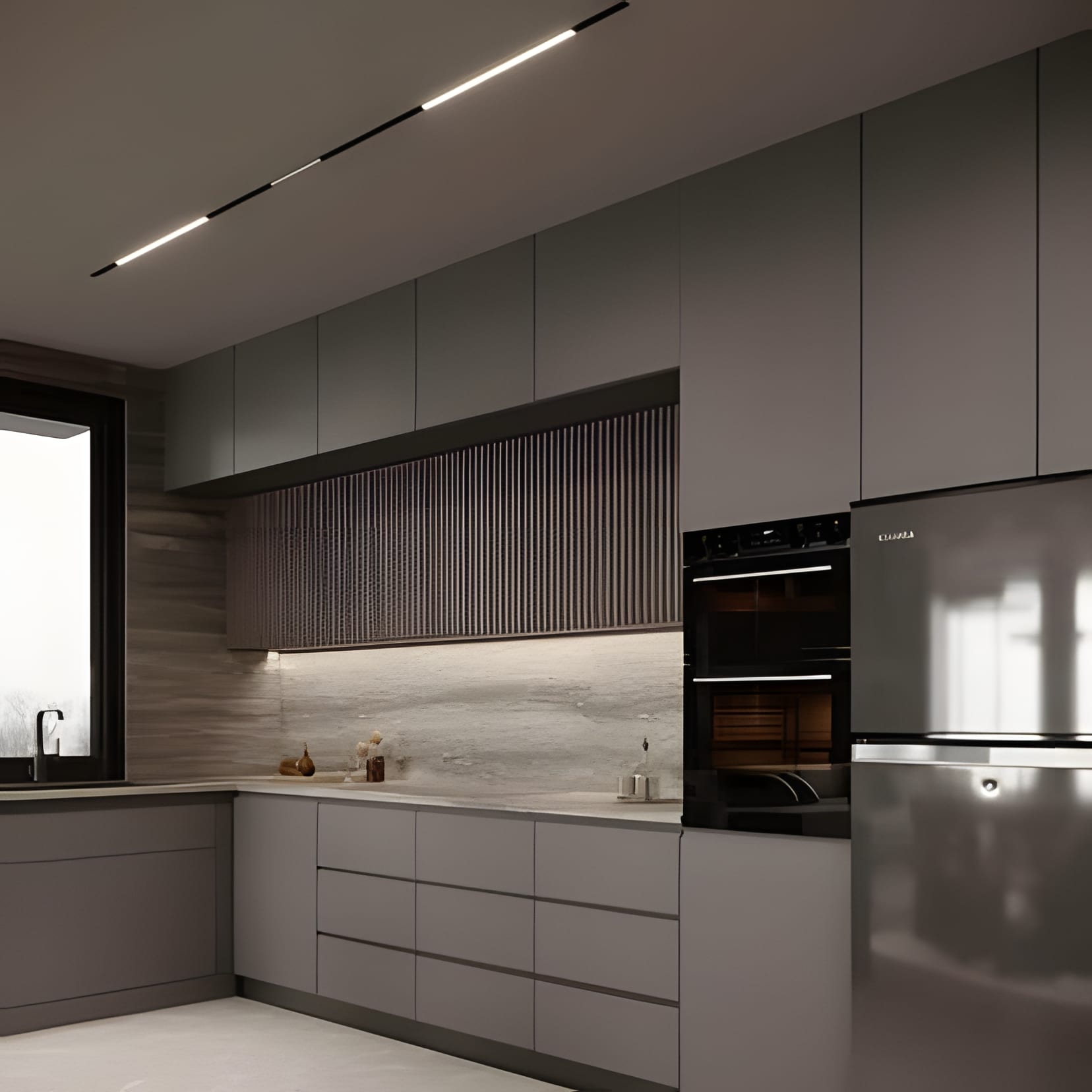 A quiet pewter-grey L-shaped kitchen with a steel fridge and nothing it doesn't need.