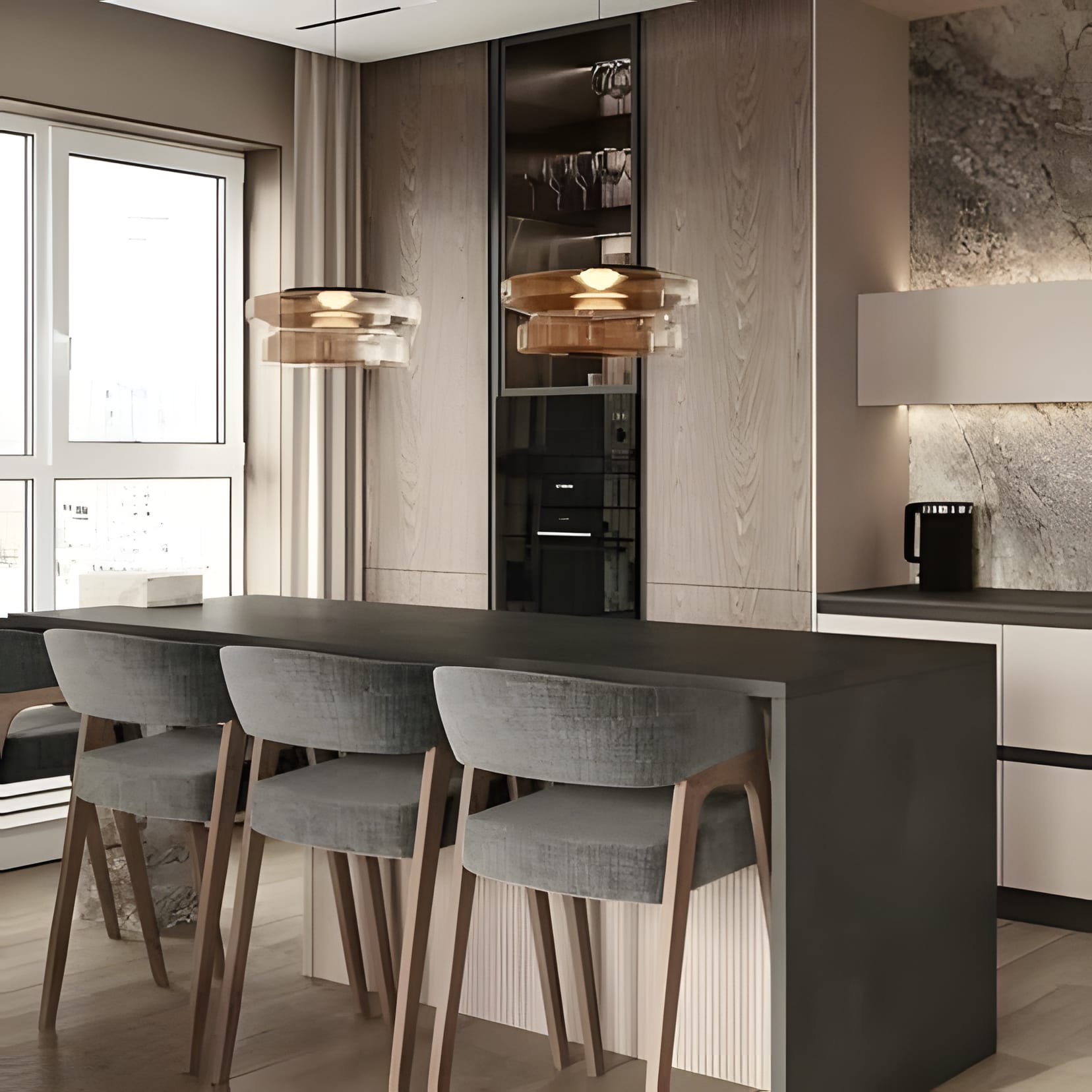 A charcoal breakfast counter with soft grey stools under amber glass pendants, framed by warm taupe cabinetry and morning window light.