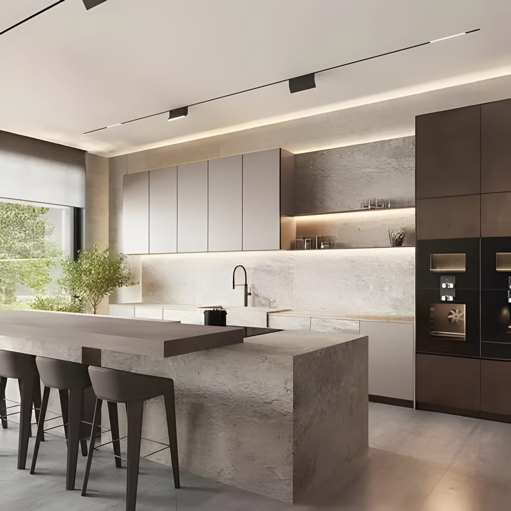 A monolithic limestone island anchoring quiet greige cabinetry, lit by a warm ribbon of light under the uppers.