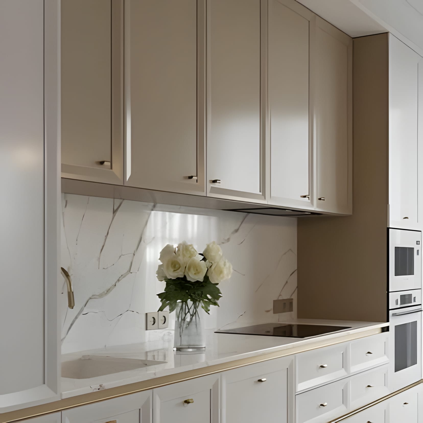 Cream cabinetry and a marble backsplash with white roses on the counter.