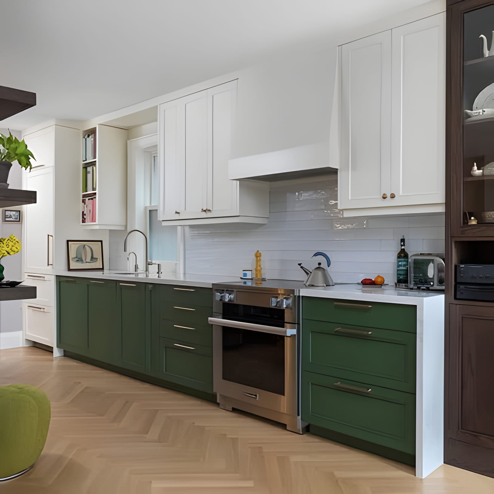 White uppers over forest-green lower cabinets, a professional range, and herringbone oak underfoot.